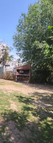 a bench in a yard next to a tree at Tintes de otoño in Mina Clavero