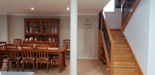 a dining room and kitchen with a table and a staircase at Southern Comfort in Point Turton