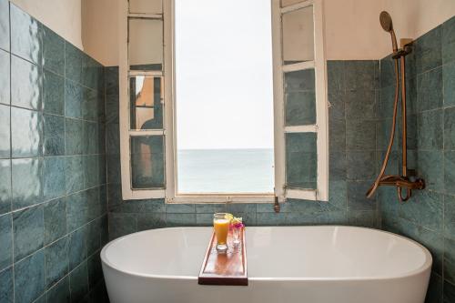 a bath tub in a bathroom with a window at Maison Crespin in Dakar