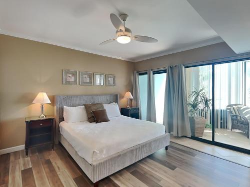 a bedroom with a bed and a ceiling fan at Palm Beach Club #125 in Pensacola Beach