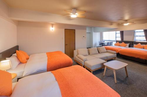 a hotel room with three beds and a couch at Miyazaki Mango Hotel - Vacation STAY 58318v in Miyazaki