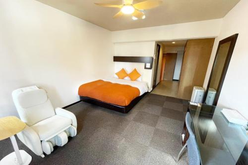 a hotel room with a bed and a chair at Miyazaki Mango Hotel - Vacation STAY 58298v in Miyazaki