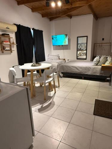 a living room with a bed and a table and chairs at MerloINK3 in Merlo