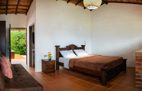 a bedroom with a bed and a couch at Finca Mr Bueno Barichara in Barichara