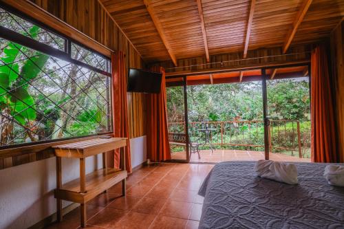 a bedroom with a bed and a large window at Cabañas La Pradera in Monteverde Costa Rica