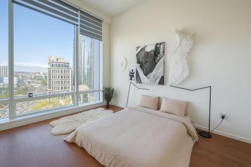 Un dormitorio con una cama y una ventana grande. en Skyline Serenity Penthouse, en Los Ángeles
