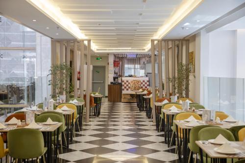 a restaurant with tables and chairs on a checkered floor at Hotel 21 Makkah in Makkah