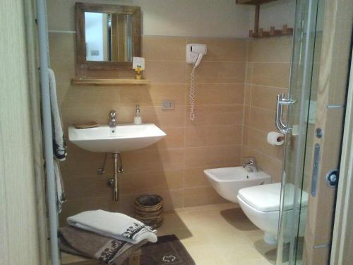 a bathroom with a sink and a toilet and a mirror at La Niche B&B in La Thuile