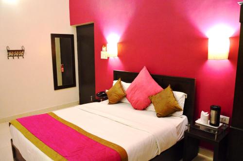 a bedroom with a large bed with red walls at La Casa in Haridwār