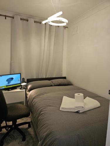 a bedroom with a bed and a desk with a computer at Eusty Guest House in Sittingbourne