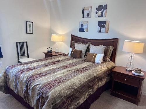 a bedroom with a large bed with two lamps and two chairs at Toy Story Getaway Retreat in Kissimmee