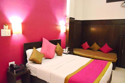 a bedroom with a large bed with pink walls at La Casa in Haridwār