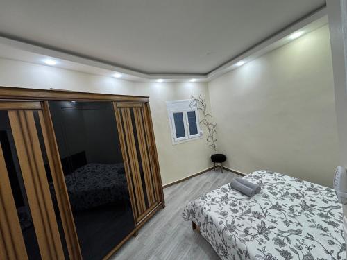 a bedroom with a bed and a glass closet at Appartement charmant avec vue sur la sur mer in Bordj el Bahri