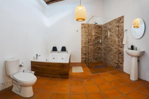 a bathroom with a tub and a toilet and a sink at Finca Mr Bueno in Barichara