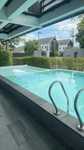 a large blue swimming pool with two metal at Norden Barn B&B in Chiang Mai