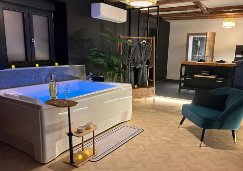 a bathroom with a blue tub and a chair at Keriana Luxe et détente privée en Alsace in Muttersholtz