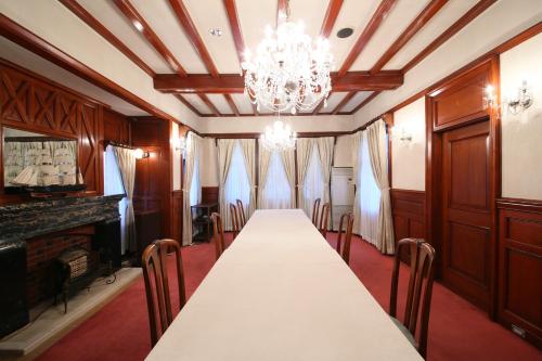 a dining room with a long table and a chandelier at Katakura Silk Hotel in Suwa
