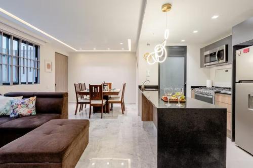 a kitchen and living room with a couch and a table at Apartamento en Roma Norte, Estilo mas Comfort in Mexico City