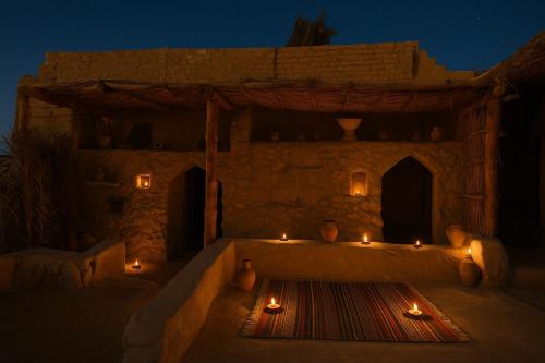 a room with candles in front of a building at night at Soléi Salt Caves in Siwa