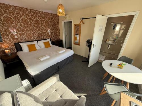 a hotel room with a bed and a table and chairs at Southsea 2nd Floor Studio Apartment, Free Private Parking in Portsmouth