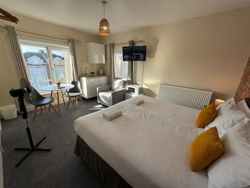 a hotel room with a large bed and a table at Southsea 2nd Floor Studio Apartment, Free Private Parking in Portsmouth