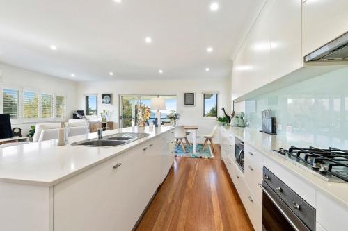 a kitchen with white counters and a white counter top at Killarney at Old Erowal Bay in Erowal Bay