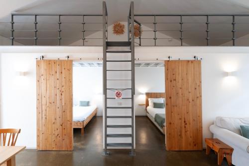 a room with two bunk beds and a ladder at Casa do Pisão - Cosy and Modern Two-Bedroom Townhouse in Angra do Heroísmo