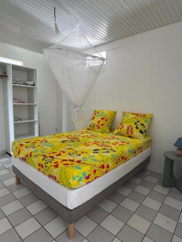 a bedroom with a bed with colorful sheets and pillows at Maison Panorama 2 chambres in Sainte-Luce