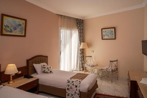 a hotel room with two beds and a window at Dexon Roma All Inclusive Hotel in Hurghada