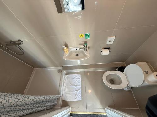 a small bathroom with a sink and a toilet at Southsea 2nd Floor Studio Apartment, Free Private Parking in Portsmouth