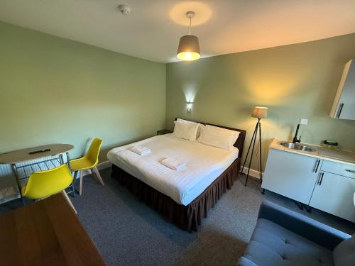 a bedroom with a bed and a table and a sink at Southsea 2nd Floor Studio Apartment, Free Private Parking in Portsmouth