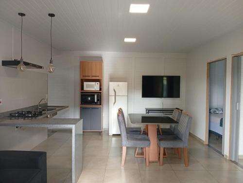 a kitchen with a table and chairs in a room at Chacara Recanto dos Querubins 2 in Cambé