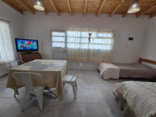 a room with a table and a bed and a tv at Rincón del Valle Gaiman in Gaiman