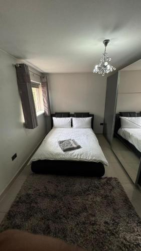 a bedroom with a large bed and a rug at Family & Contractors 3 BR Bungalow Cot Garden Netflix Coffee Station in Great Barr
