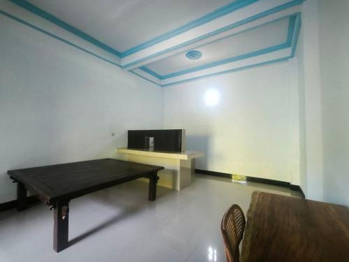 een kamer met een tafel en een tv aan de muur bij Pondok Segara Guesthouse in Padangbai