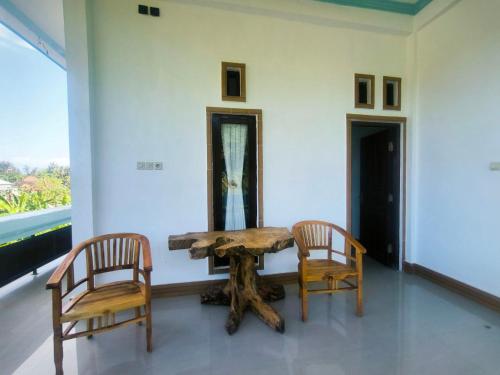 een houten tafel en 2 stoelen in een kamer bij Pondok Segara Guesthouse in Padangbai