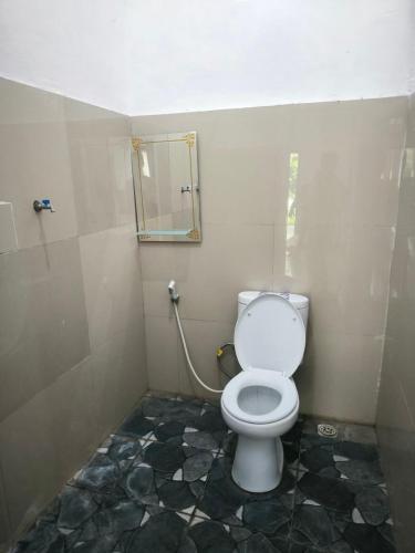 a bathroom with a toilet and a mirror at Pondok Segara Guesthouse in Padangbai