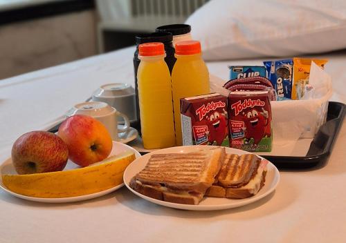 een tafel met een ontbijt van toast, fruit en sap bij Motel das Nações in Bauru