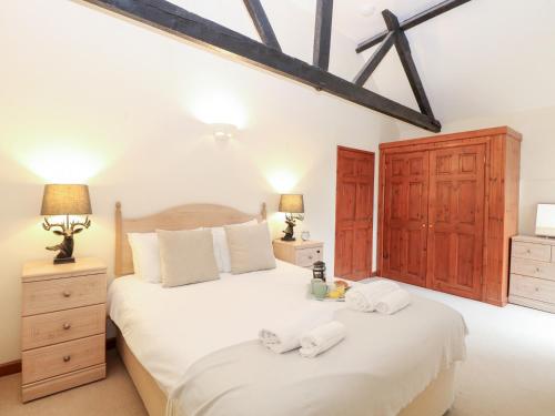 a bedroom with a large bed with towels on it at Willow in Wood Norton