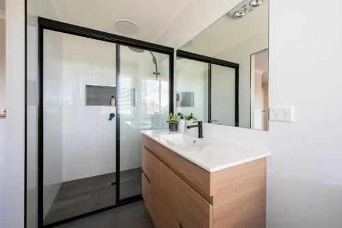 Un baño con lavabo y ducha en Capel Grand Villa - Pet-Friendly Beach Escape, en Rosebud