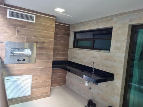 a bathroom with a sink and a window at Apartamento Frente pra Praia em Resort in Arraial do Cabo