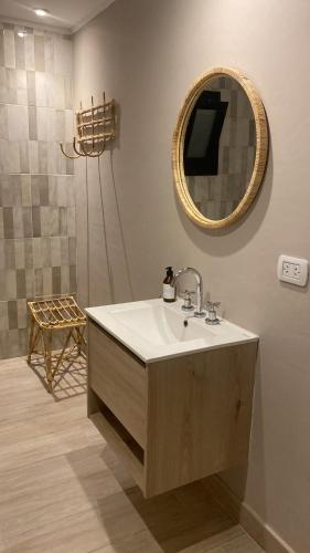 un baño con lavabo y espejo en Senderos del Mar II, en Monte Hermoso