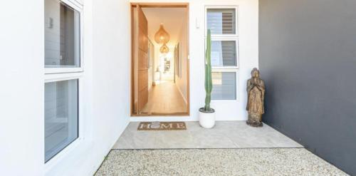a hallway with a door and a plant in a vase at Sage Studio in Alstonville