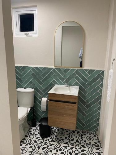 a bathroom with a sink and a toilet and a mirror at Mereri downtown appartments in Oranjestad