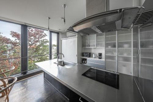 a kitchen with a counter and a large window at Townhouse Asahikawa in Asahikawa