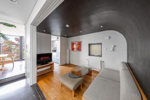 a living room with a couch and a tv at Townhouse Asahikawa in Asahikawa