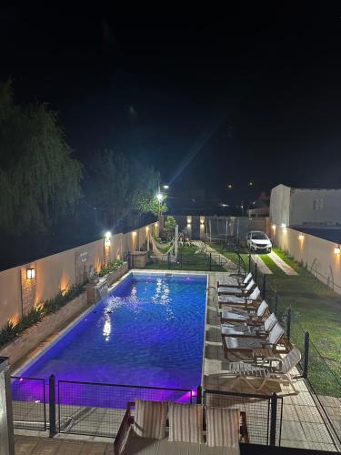 a swimming pool at night with lounge chairs around it at Casa Quincho concordia in Villa Zorraquín
