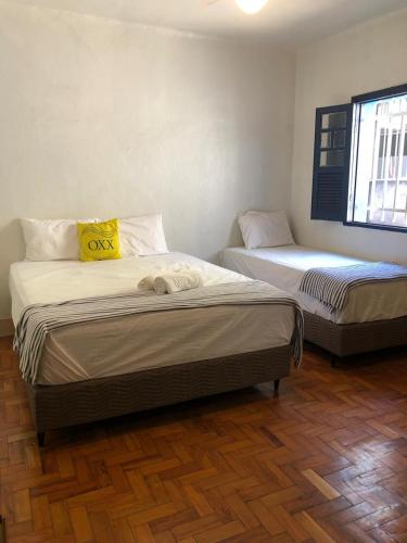twee eenpersoonsbedden in een kamer met bij Oxx in Congonhas
