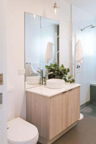 a bathroom with a sink and a toilet and a mirror at B e a c h H o u s e X I V in Bicheno