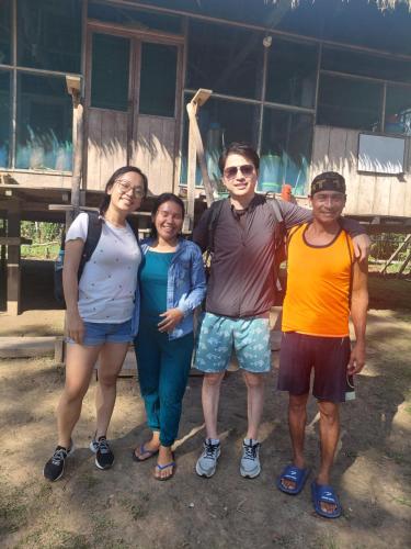a group of people standing in front of a house at Amazon tucuxi in Islas Timicuro